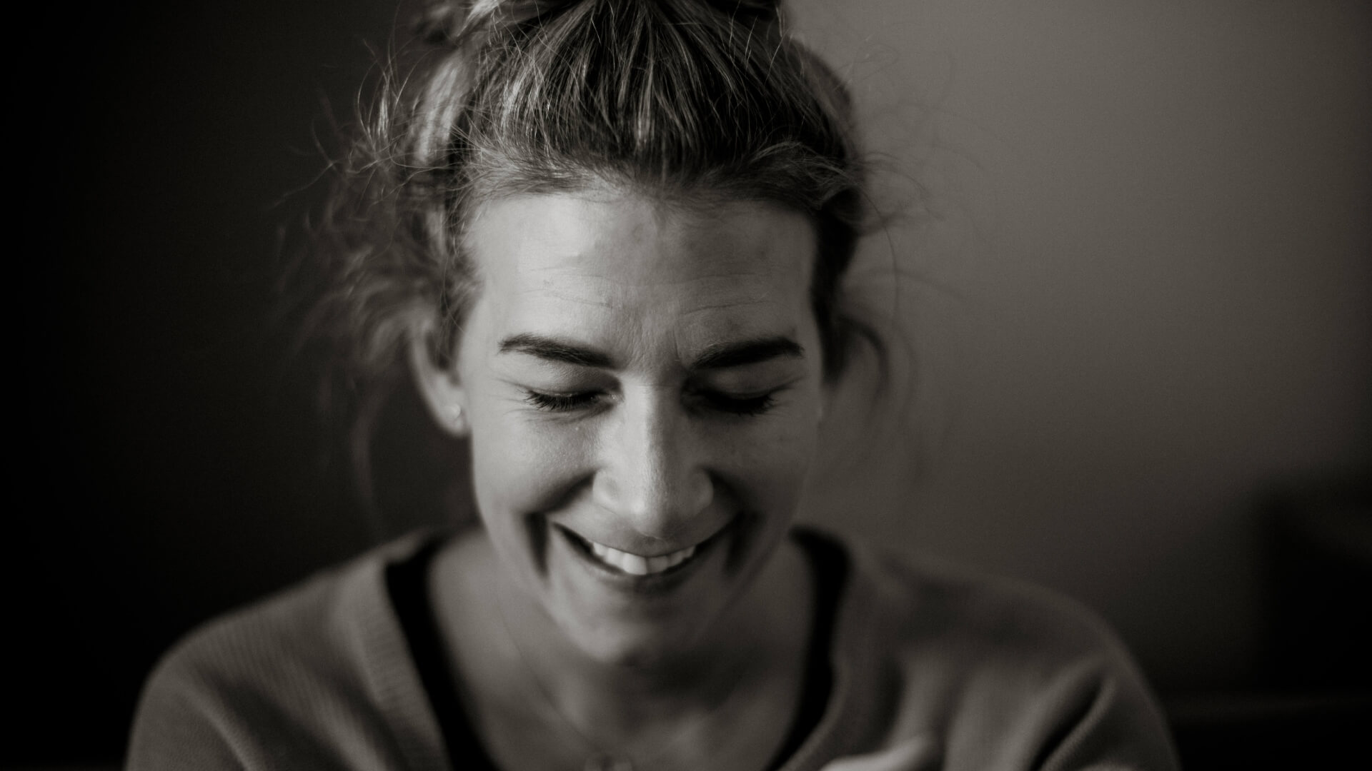 Black and white close-up of Lou Fitz from BESHU smiling with her eyes closed